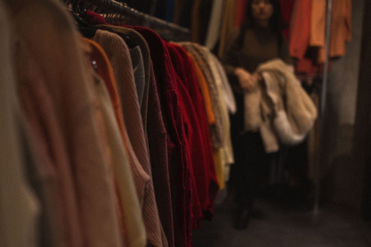 Une cliente choisit un vêtement dans une boutique